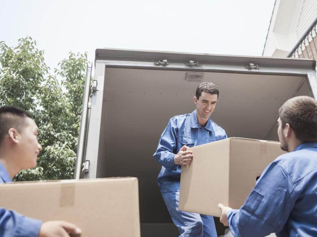 Several movers unloading objects from a truck