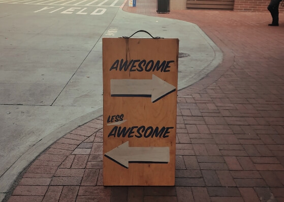 Wooden street signboard with right arrow awesome and left arrow less awesome