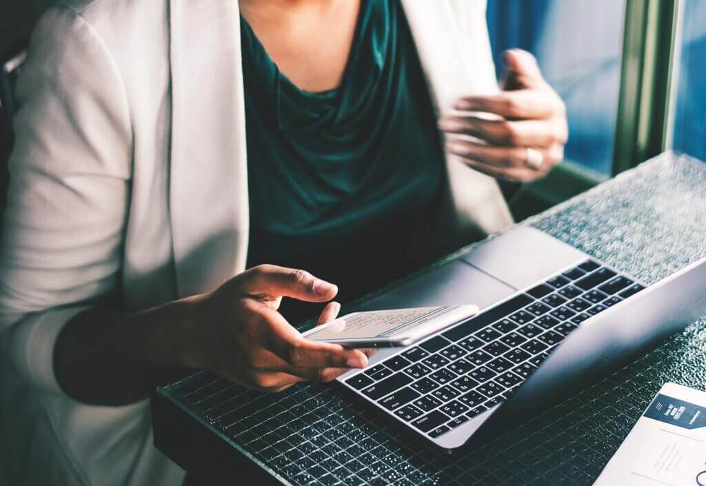 Woman using PC and smartphone at desk