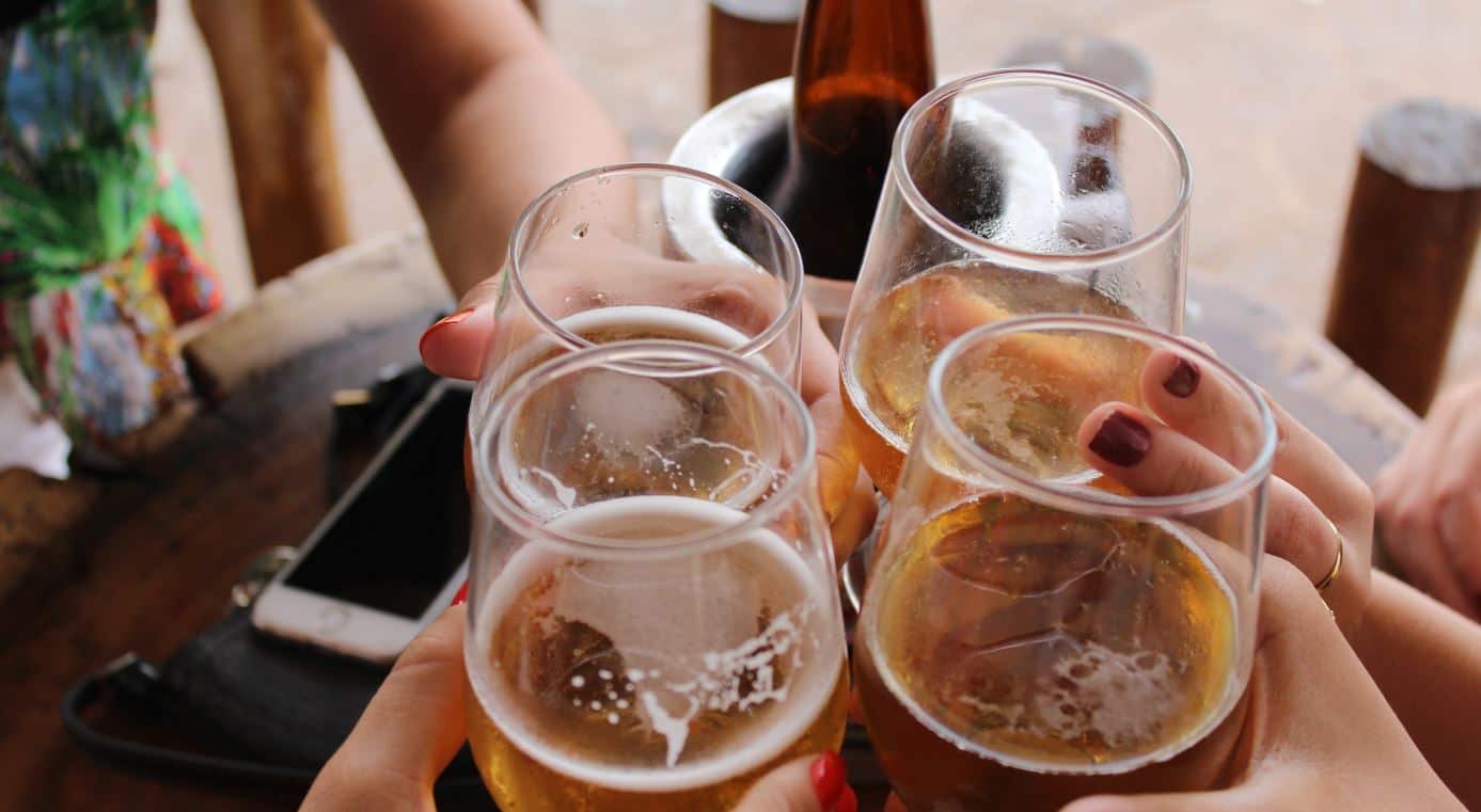 People clink beer glasses each other