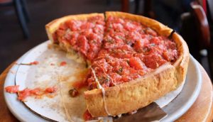 Pizzeria Uno and Due deep dish pie with a spatula