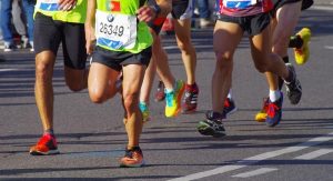 runners with numbers and shoes on road