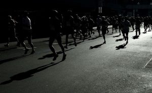 People running a marathon in the pitch black darkness