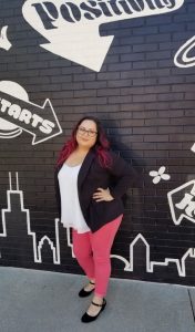 lady standing in front of black brick wall